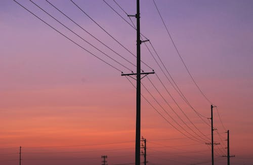 Silhouette of Electric Posts Under Red Sky