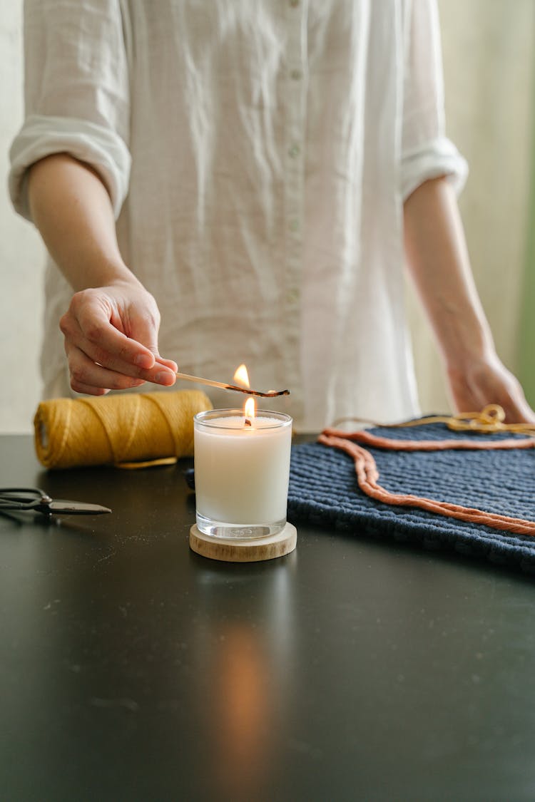 Hand Lighting A Candle Using A Matchstick