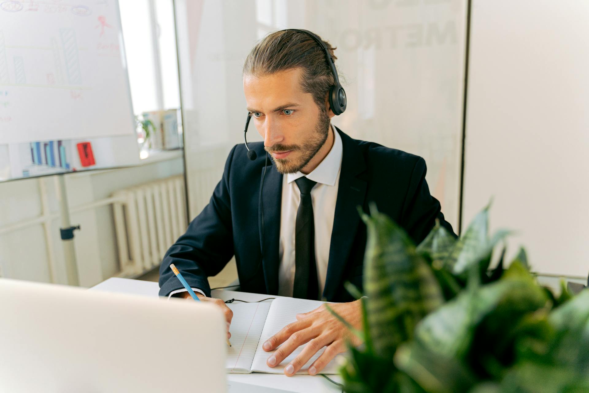 A professional customer service agent focuses intently while working at his desk in an office setting.