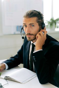 Focused call center agent in business suit working with headset at modern workplace.