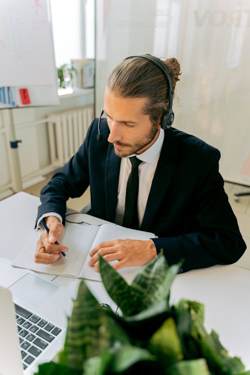 Free Man in Black Suit Jacket Writing on Notebook Stock Photo