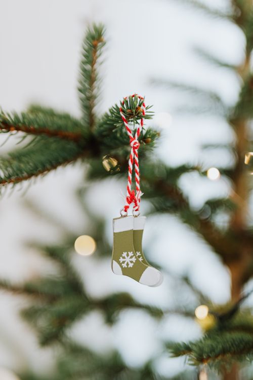 Free Close-up of a Christmas stocking ornament hanging on a decorated tree branch. Stock Photo