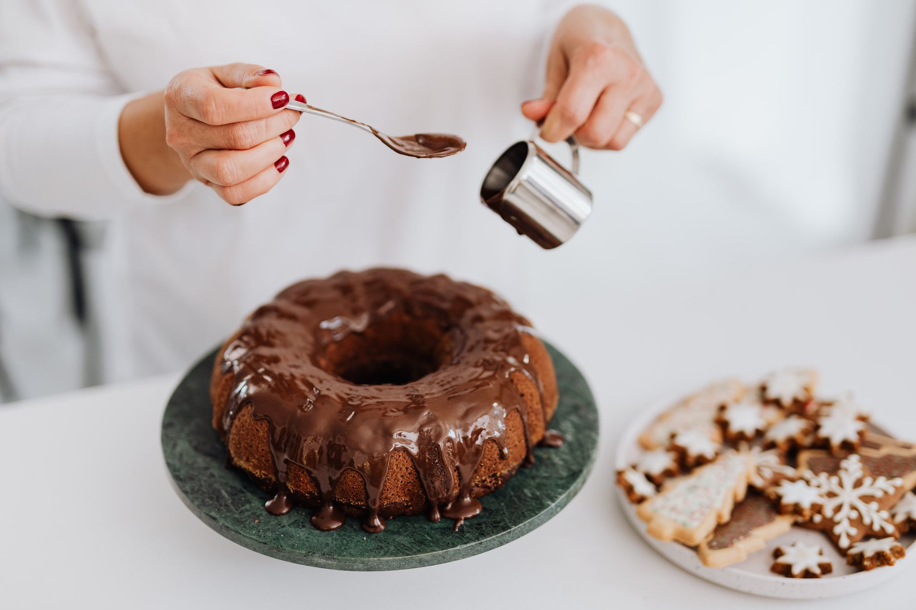 Chocolate frosting being spread on lemon cake