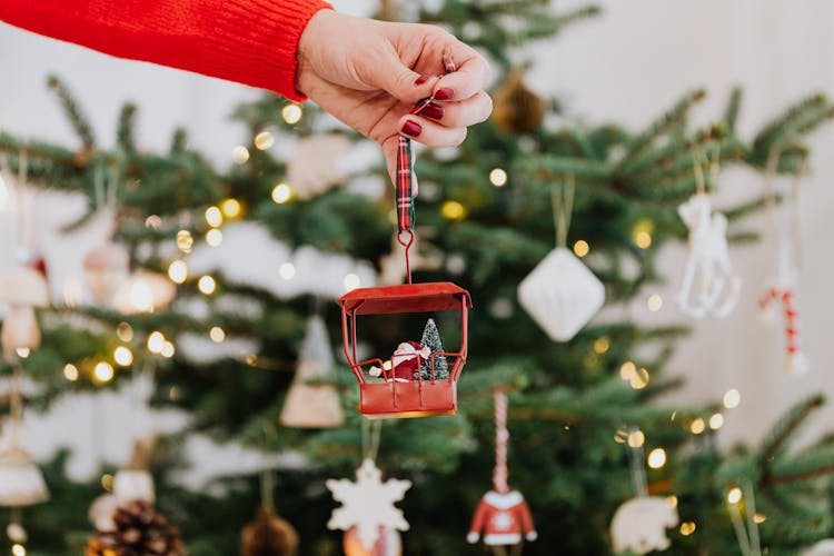 A Person Holding A Christmas Ornament