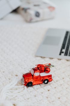 特写镜头捕捉了针织表面上红色玩具卡车的装饰，传递出节日的温暖