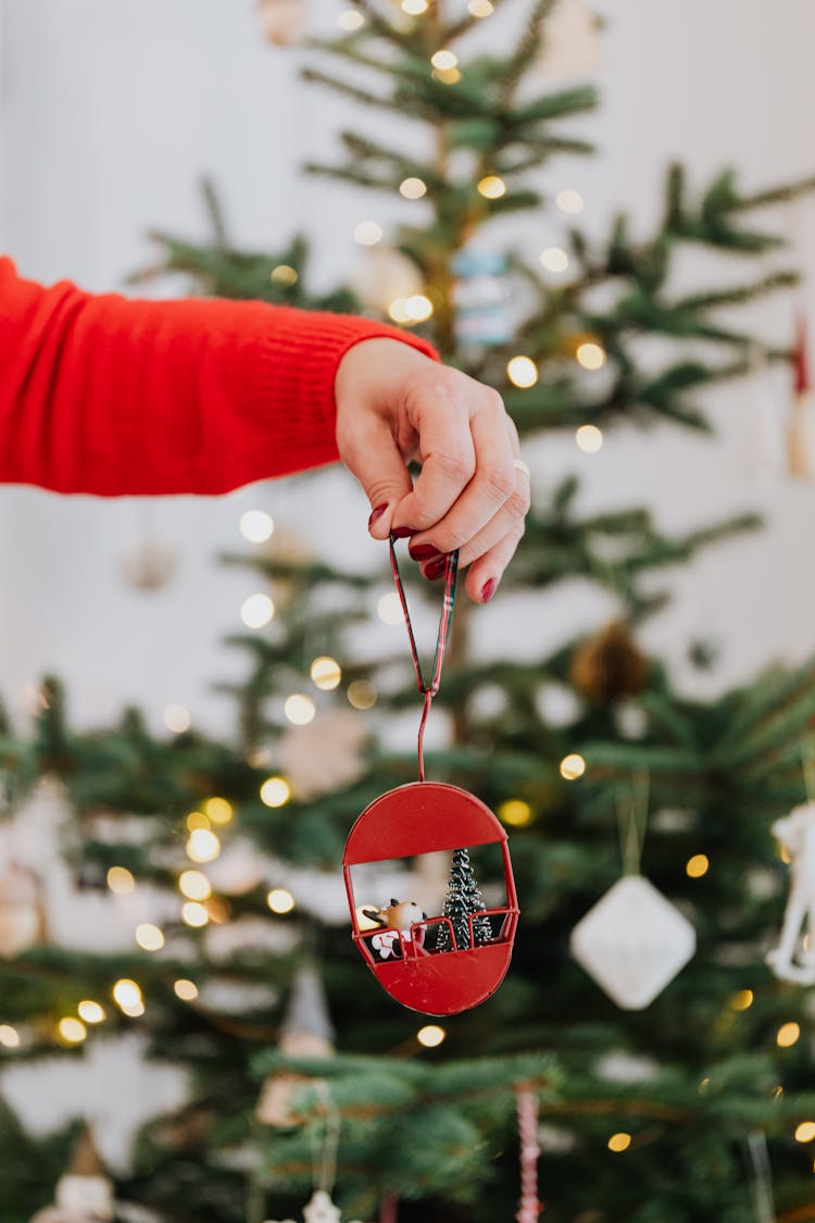 A Person Holding A Christmas Ornament