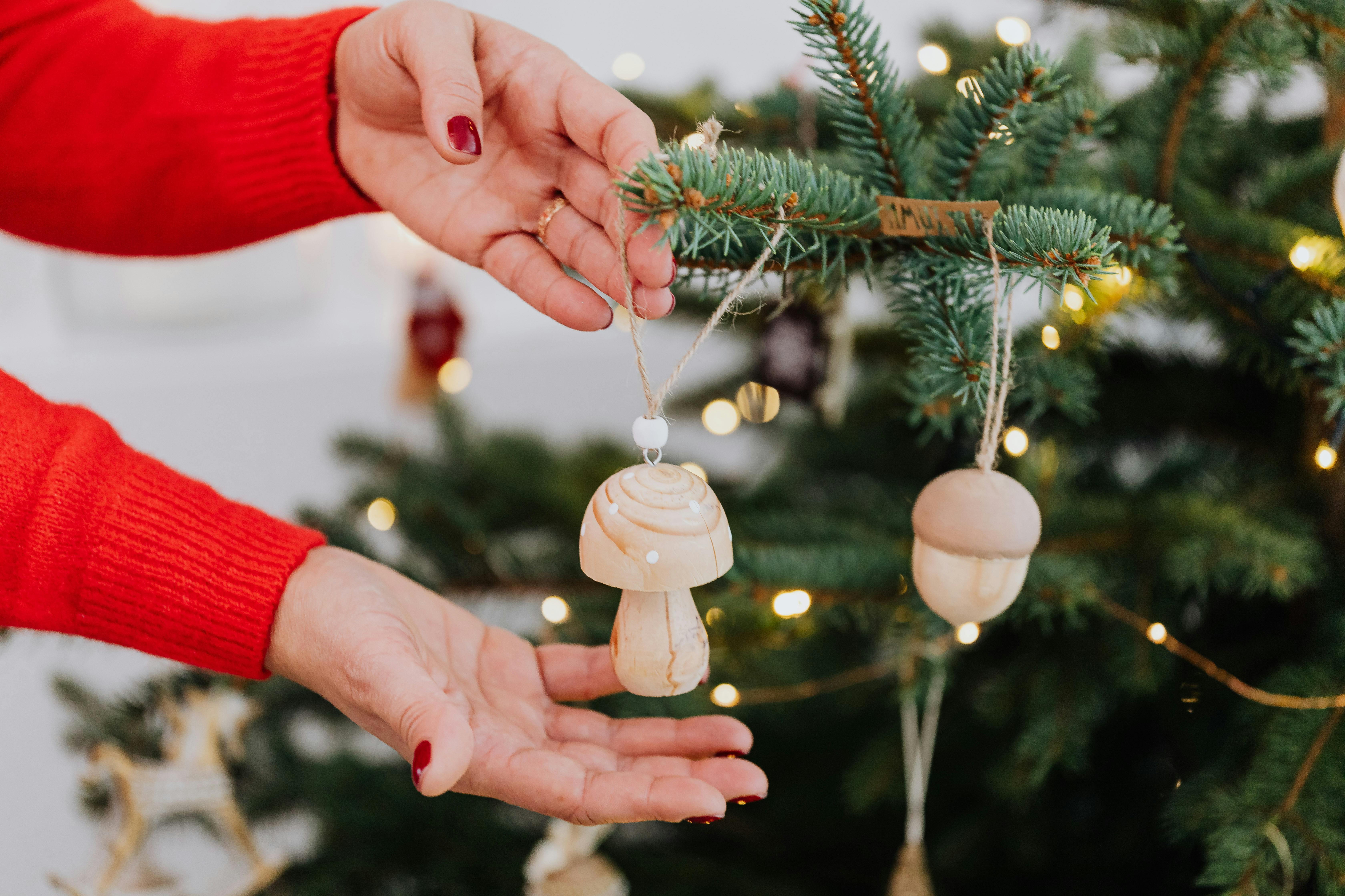person holding a white mushroom shaped christmas ornament
