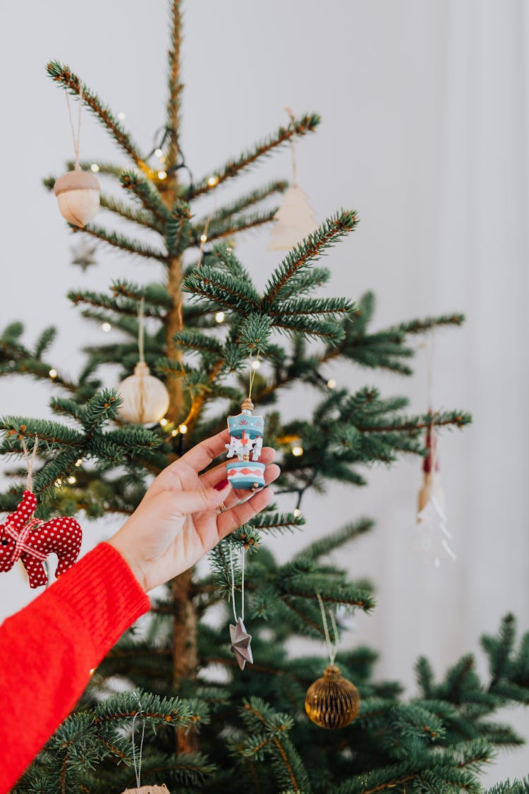 Person Holding A Hanging Christmas Ornament