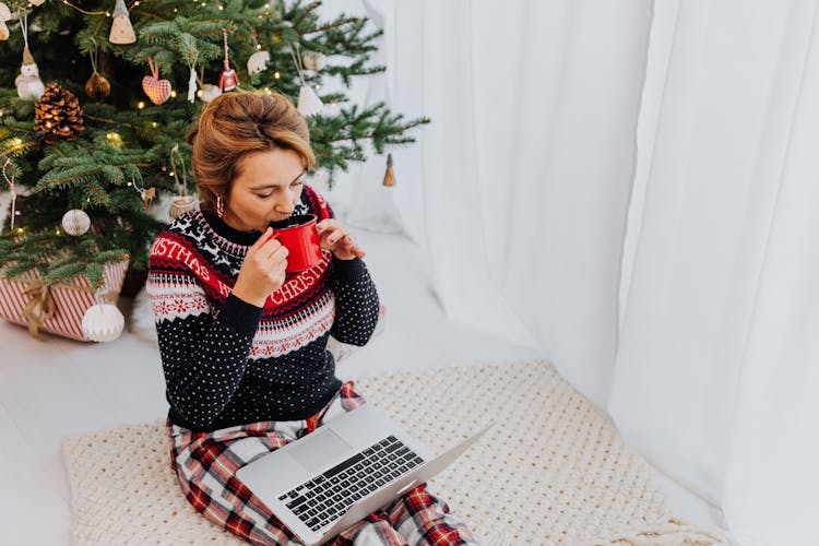 Woman Near Christmas Tree Working On Computer