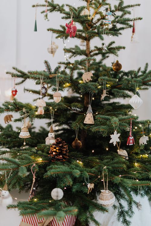 Free Festive Christmas tree adorned with various ornaments and tinsel, capturing holiday spirit. Stock Photo