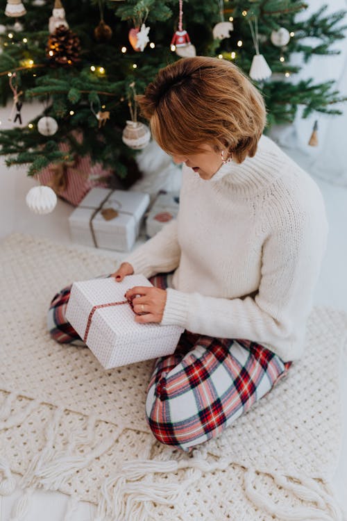 Woman in White Sweater Opening a Gift