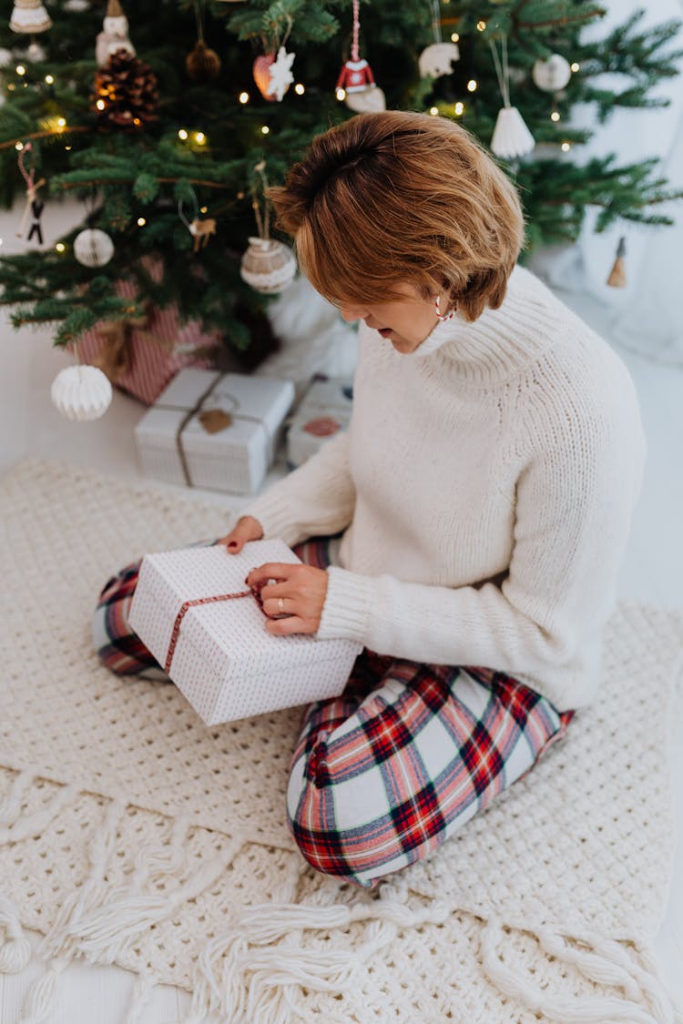 Woman In White Sweater Opening A Gift