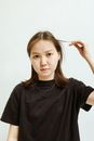 一位年轻女子身穿黑色衬衫，在浅色背景下拍摄的特写肖像