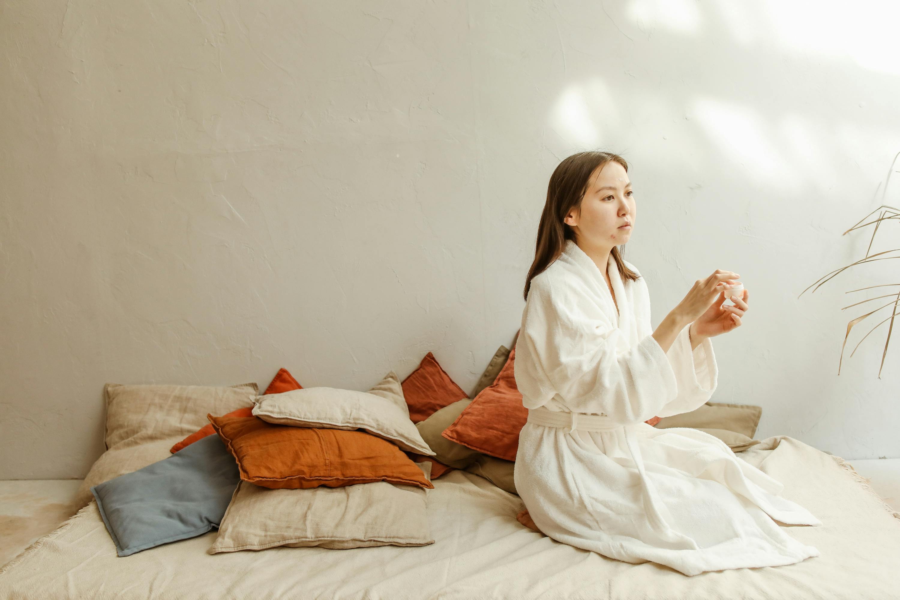 Woman in White Robe Sitting on Bed · Free Stock Photo