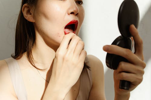 Woman Putting on Red Lipstick