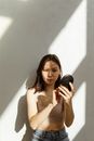 Woman in Beige Crop Top Putting on Makeup