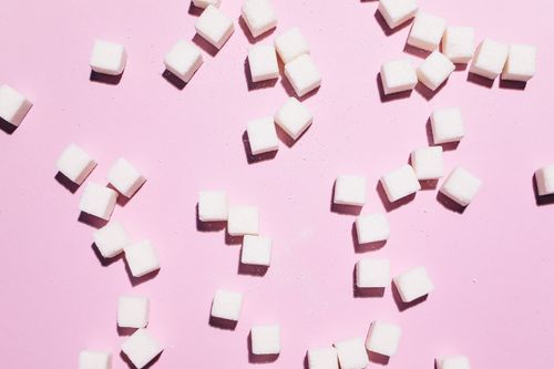 Free Flat lay of sugar cubes scattered over a pink surface, modern and bright. Stock Photo