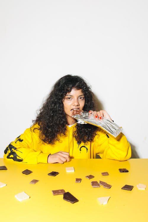 Curly-Haired Woman Eating a Chocolate Bar