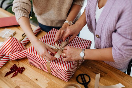 Free Close-Up Shot of a Two People Opening a Christmas Present Stock Photo