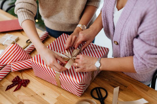 Close-Up Shot of a Two People Opening a Christmas Present