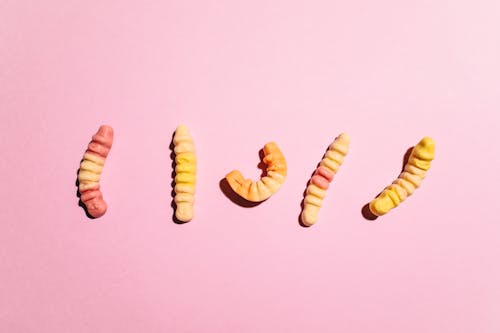 Free Close-Up Shot of Gummy Worms on Pink Surface Stock Photo