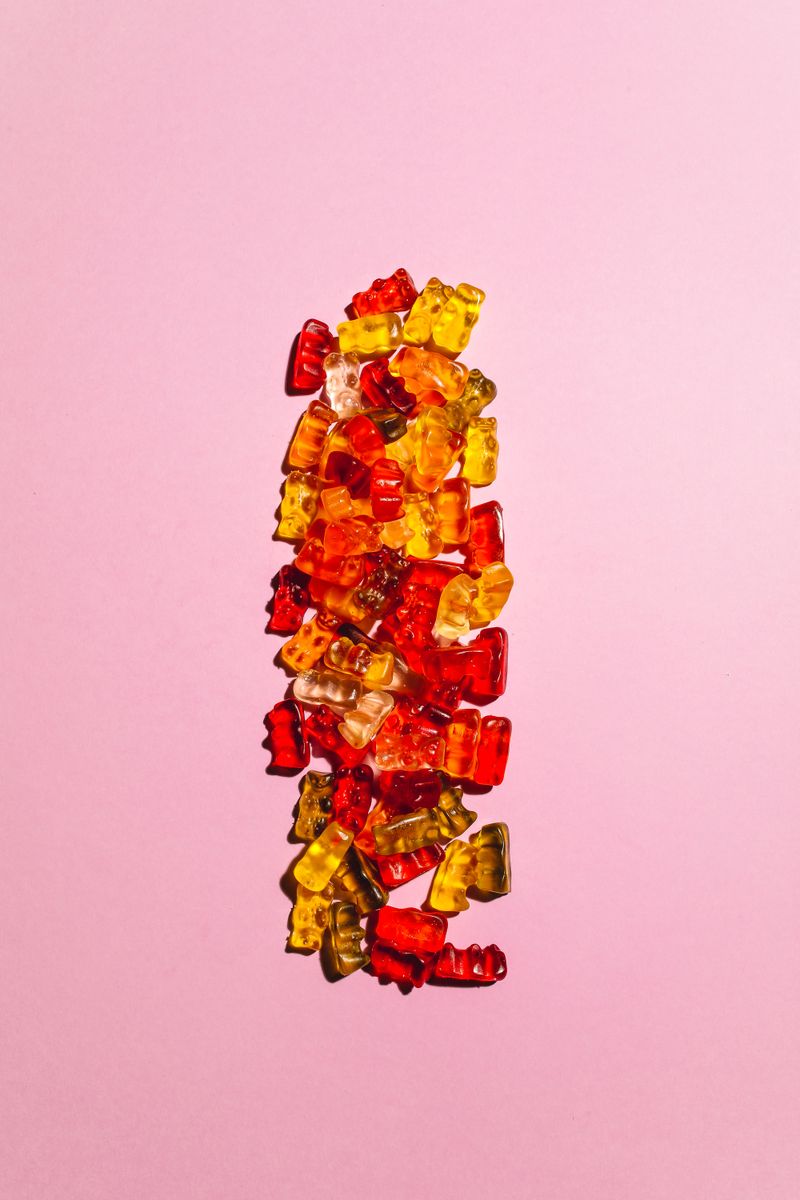 Colorful gummy bears on a pink surface