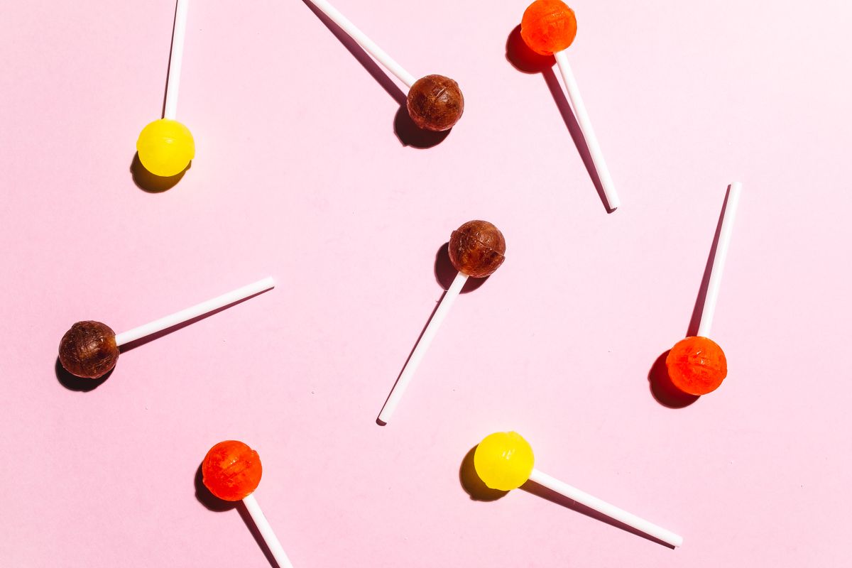 A vibrant collection of lollipops on a pastel pink surface, perfect for sweet-themed designs.