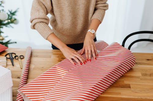 Woman in Brown Sweater Wrapping a Gift