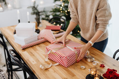 Free Woman Packing Christmas Presents on Table Stock Photo
