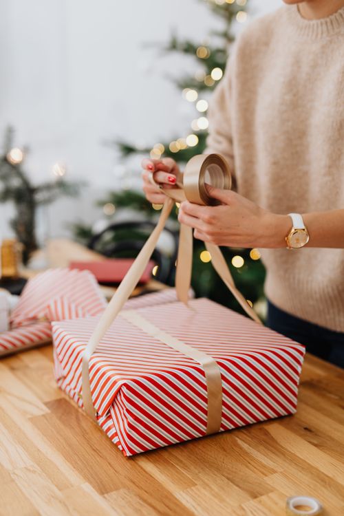 Free Elegant Christmas gift wrapping with red and white stripes on wooden table, perfect for holiday themes. Stock Photo
