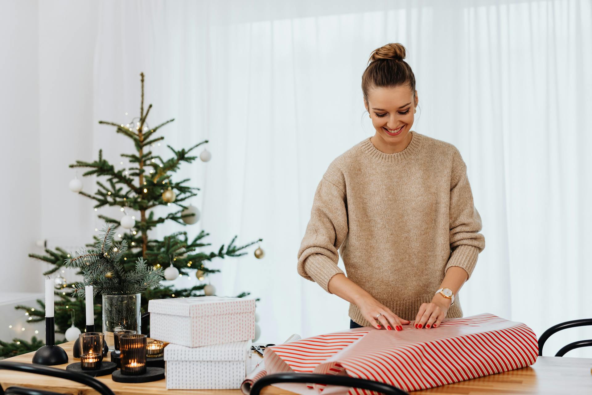A Woman in Brown Sweater Wrapping a Gift