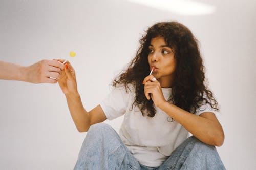 Curly-Haired Woman Eating Lollipop