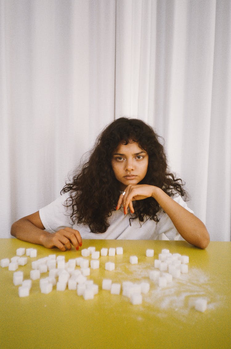 Woman Leaning On A Table With Sugar Cubes