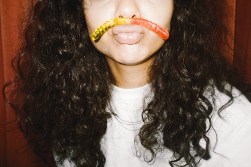 Woman with Gummy Worm on Lips