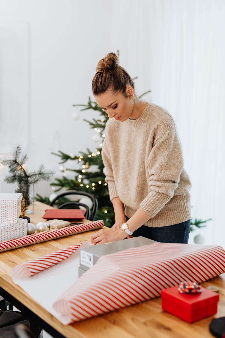 Woman In Beige Sweater Wrapping A Gift