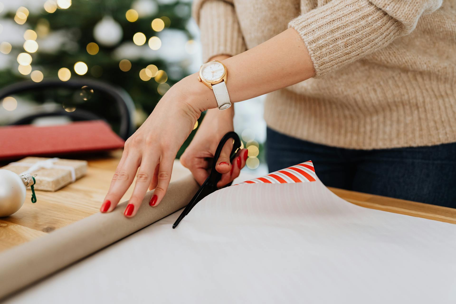 Person Cutting Gift Wrapper Using a Scissors
