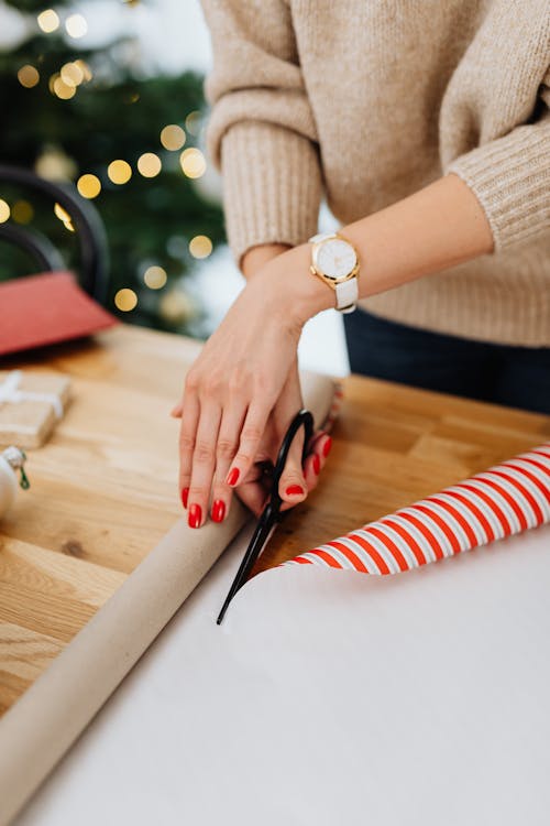 Free Person Cutting Gift Wrapper Using a Scissors Stock Photo