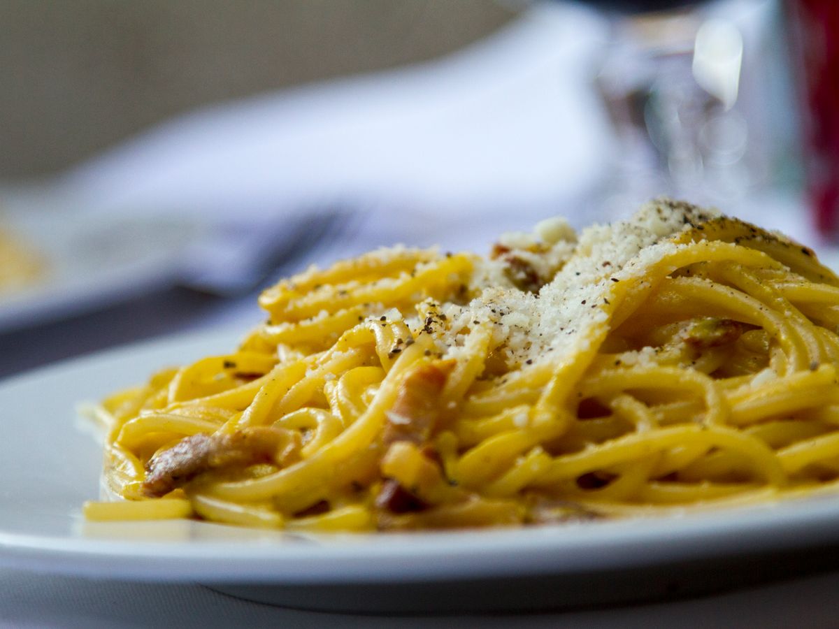 Spaghetti alla carbonara with grated cheese in a family restaurant