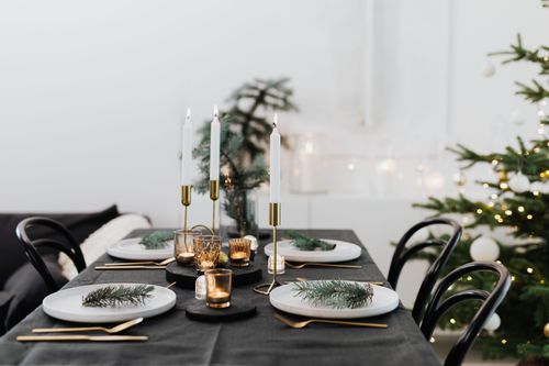 Free Festive Christmas table setting adorned with candles, pine branches, and elegant tableware. Stock Photo
