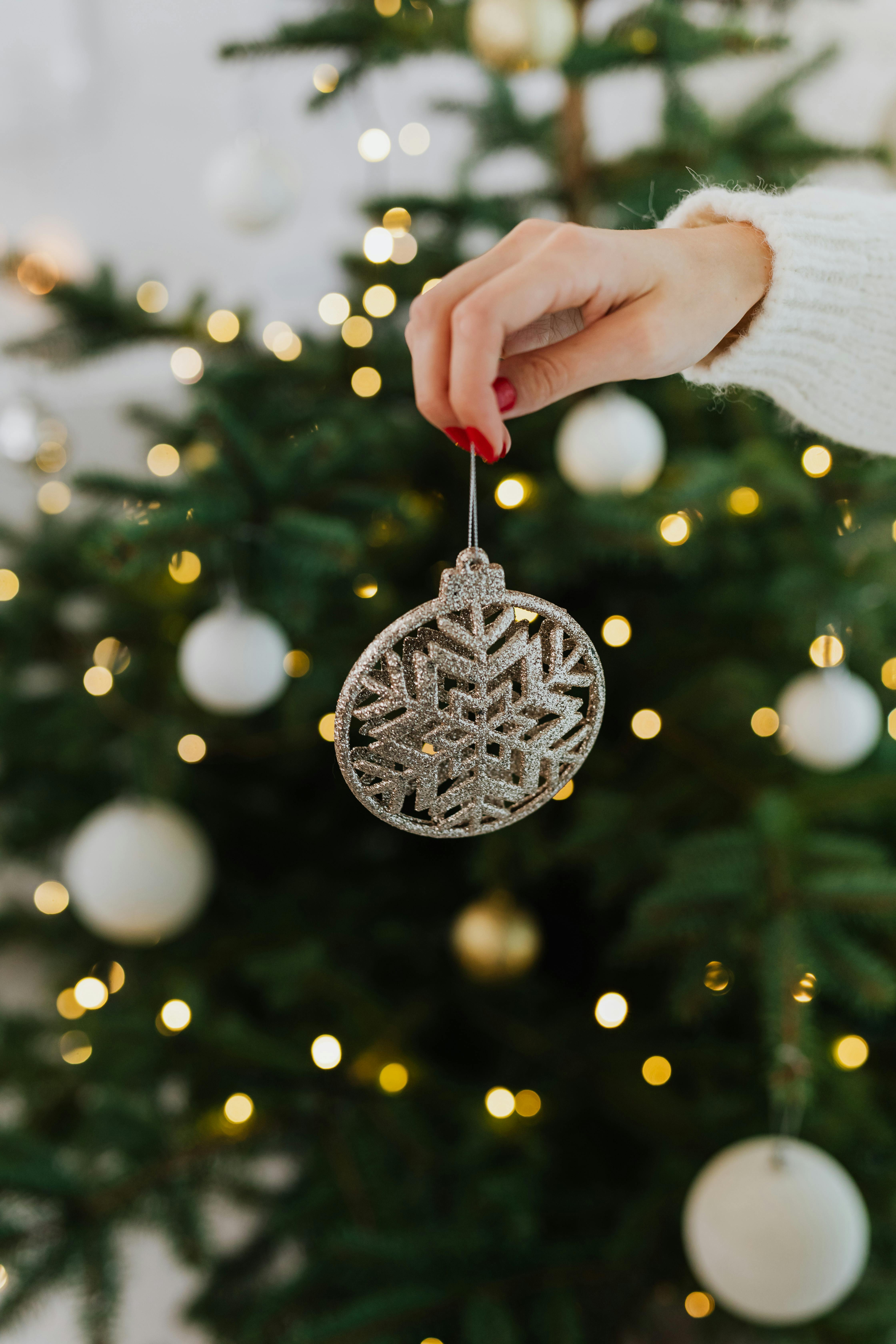 woman holding a silver christmas ornament