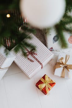 圣诞树下摆放着系有蝴蝶结和丝带的优雅礼物