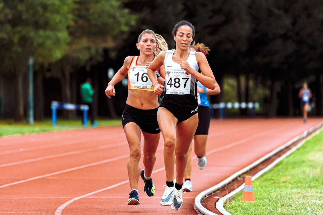 Free Fast athletes running on race track in stadium Stock Photo