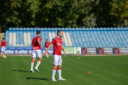 Men in Red and White Soccer Uniform Standing On The Field