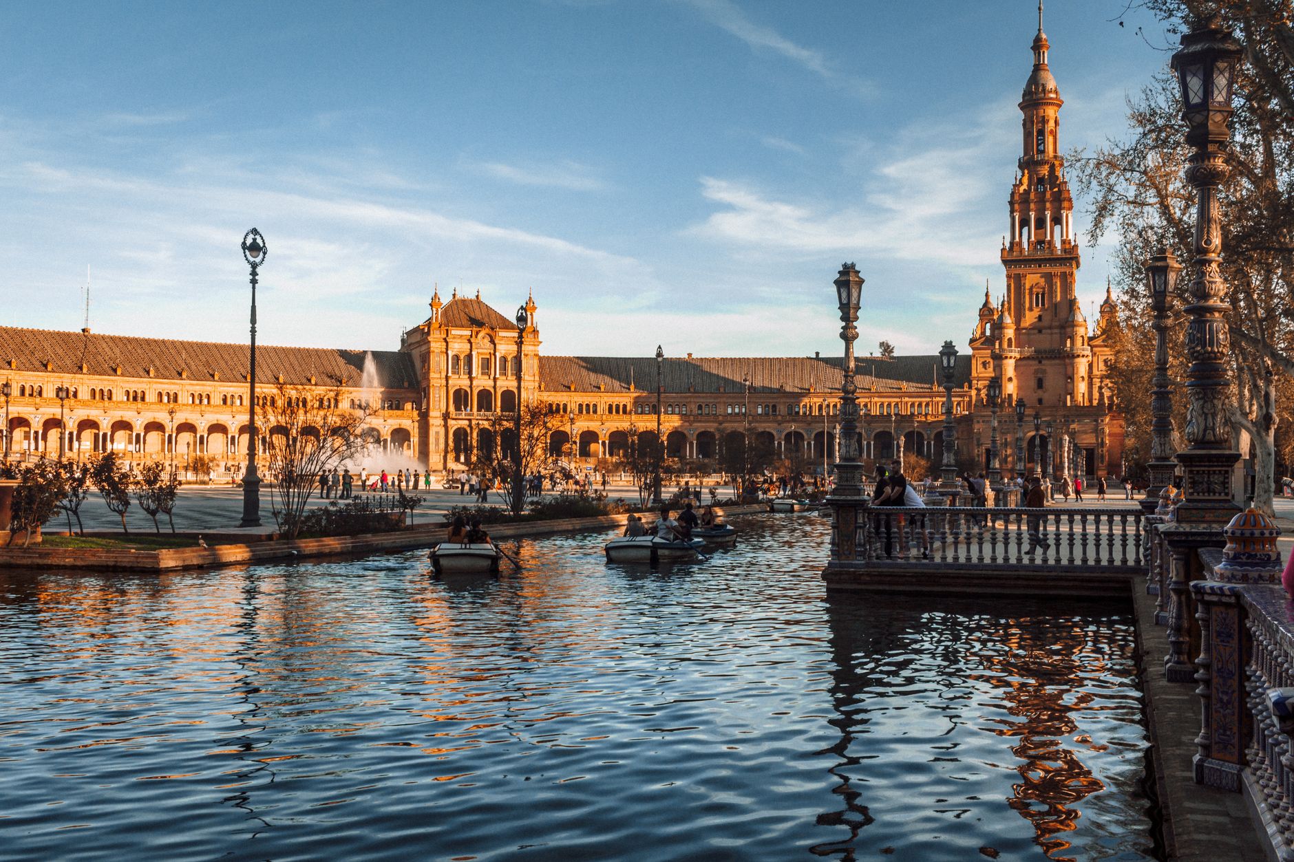 Scenic view of Plaza de España in Seville with reflections on the canal at sunset.