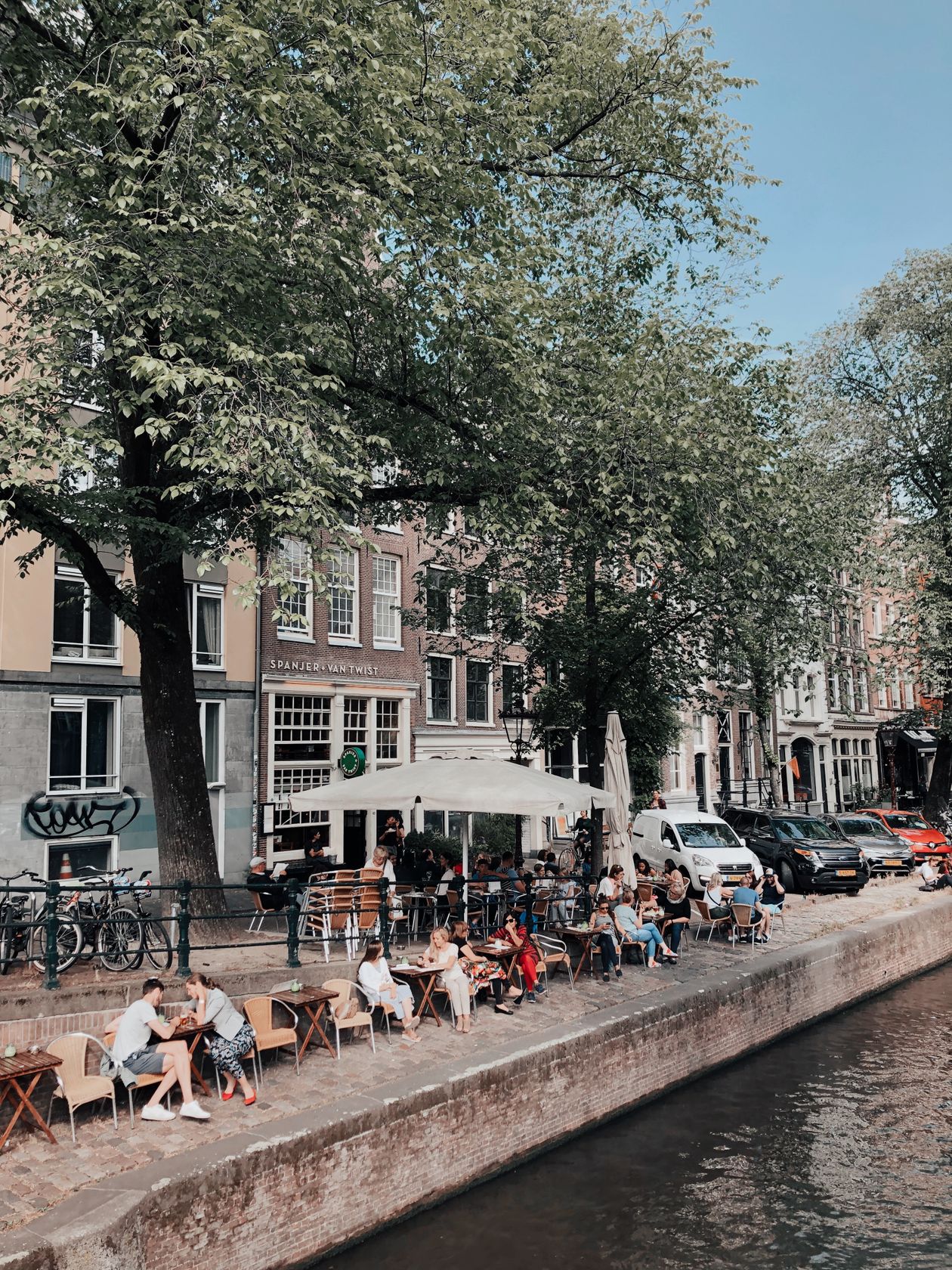Quán cà phê bên bờ kênh ở Amsterdam, khách ngồi thư thả dưới nắng hè