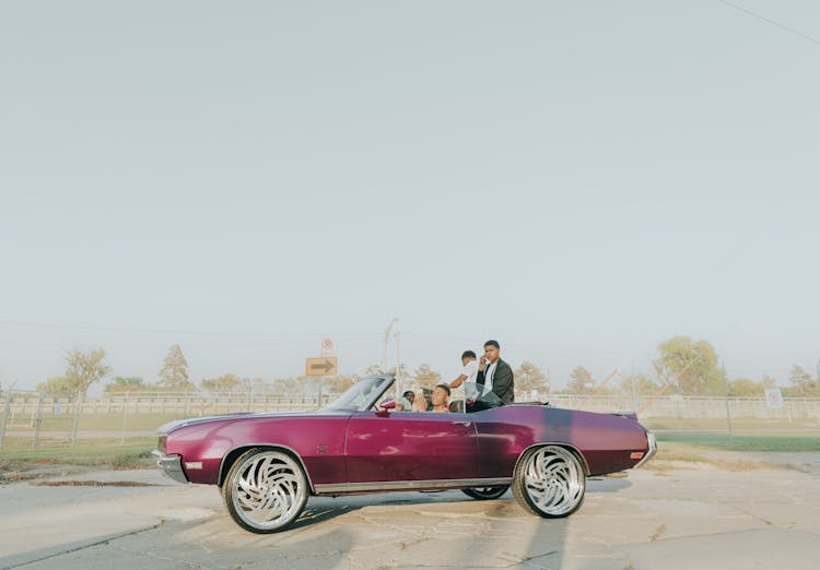 People Riding A Purple Car