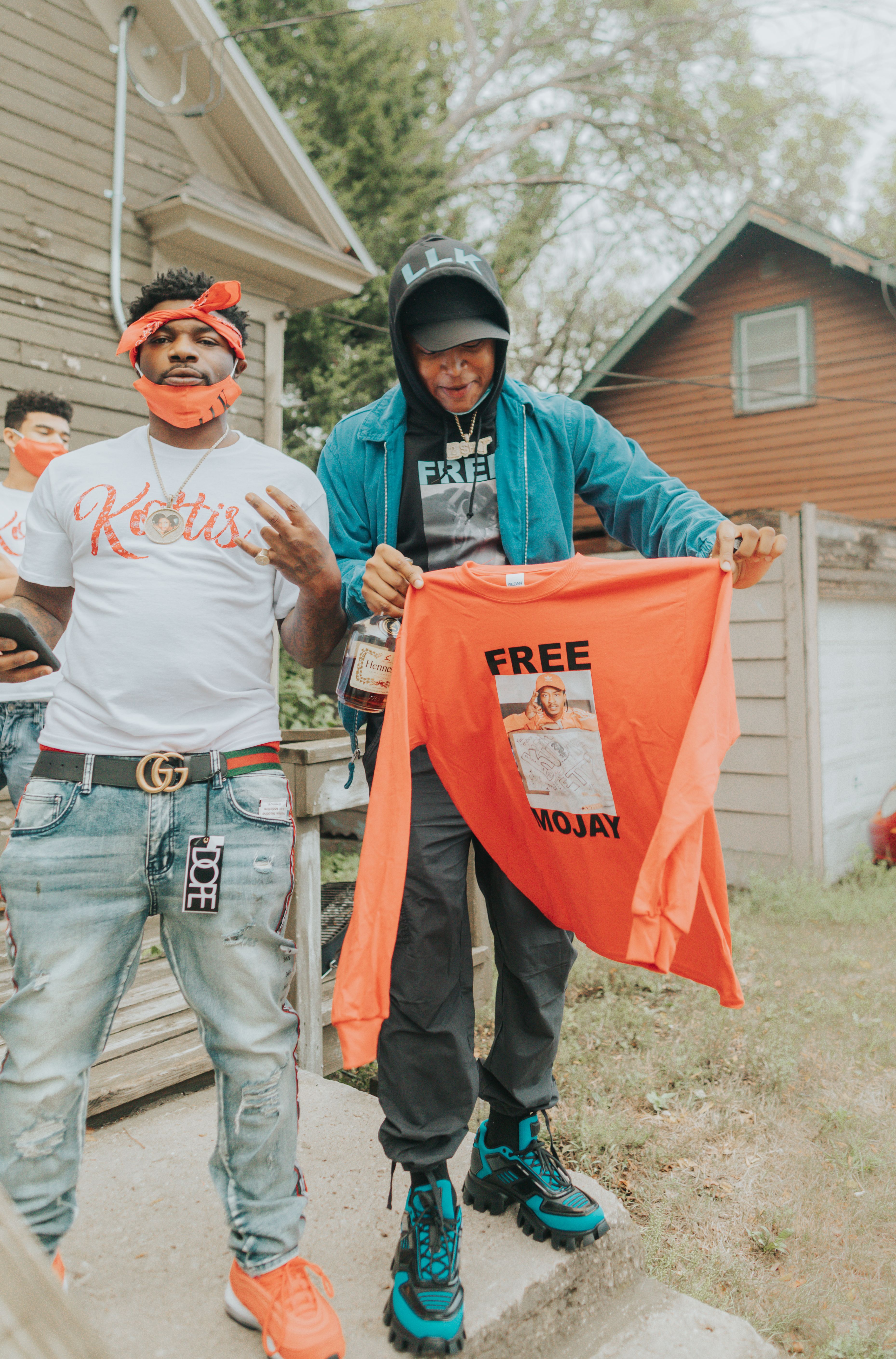 Two men outdoors show solidarity with an orange shirt in Fort Dodge, Iowa.