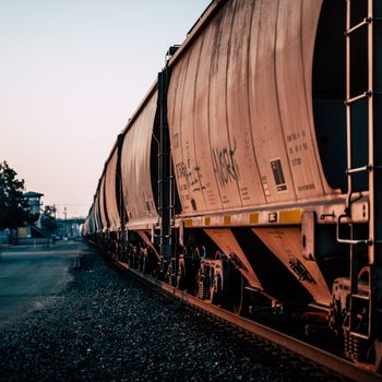 Large metal rusty train for carrying goods on railroad at station at daytime