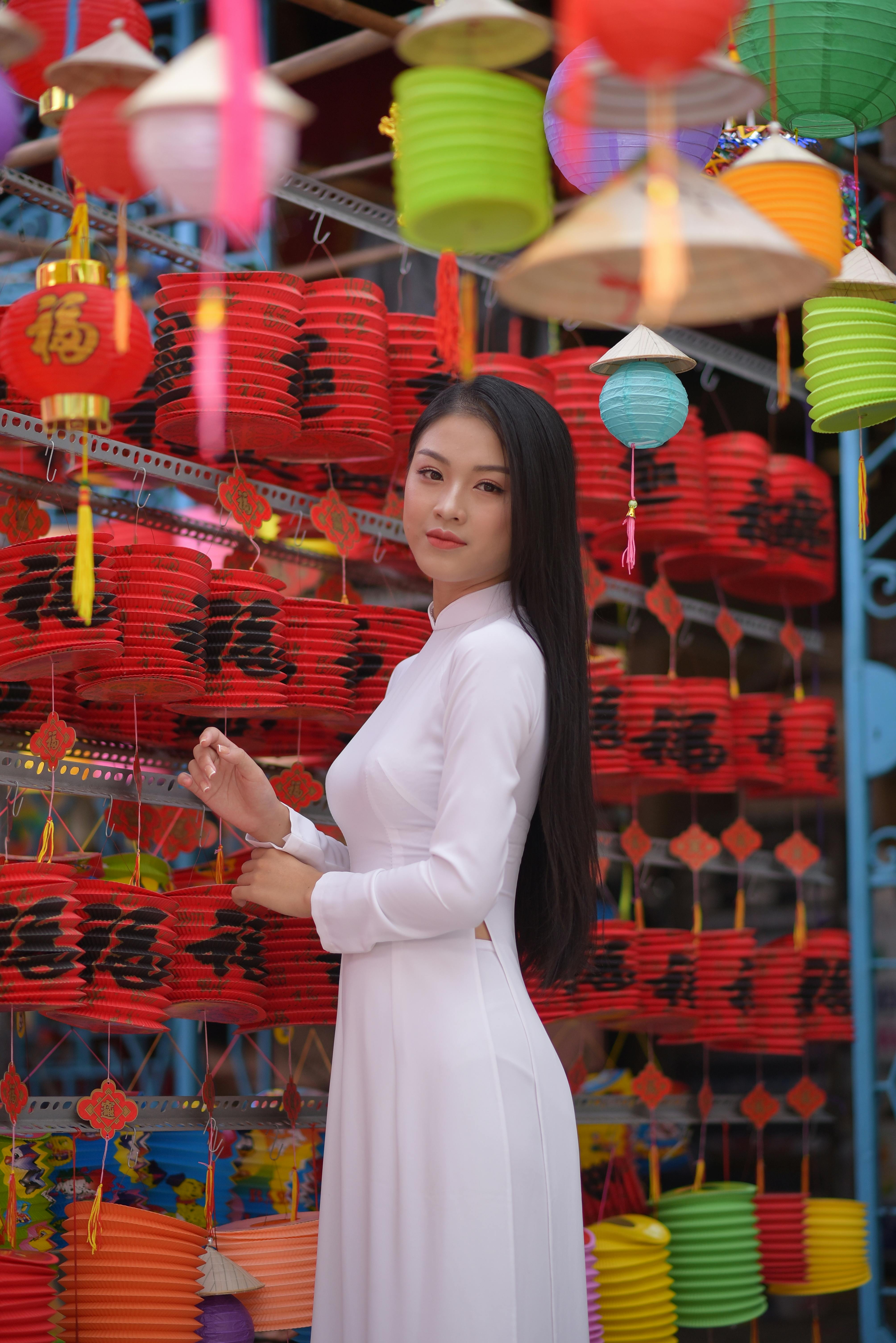 woman in traditional clothes standing near chinese lanterns