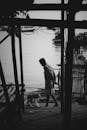Anonymous man walking on waterfront of poor city